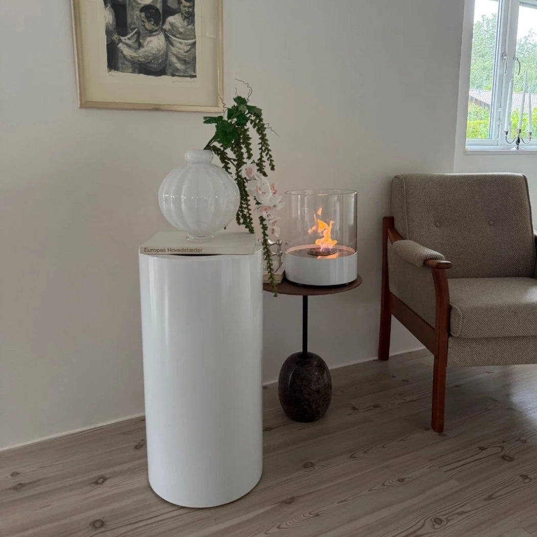 ScandiFlames Dualis bioethanol fireplace with a white fireplace body and a cylindrical safety glass