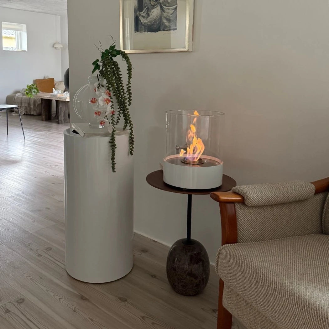 ScandiFlames Dualis bioethanol fireplace with a white fireplace body and a cylindrical safety glass