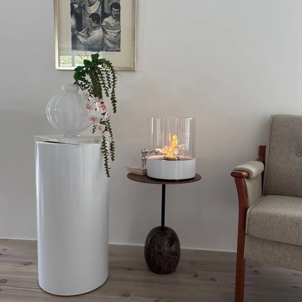 ScandiFlames Dualis bioethanol fireplace with a white fireplace body and a cylindrical safety glass