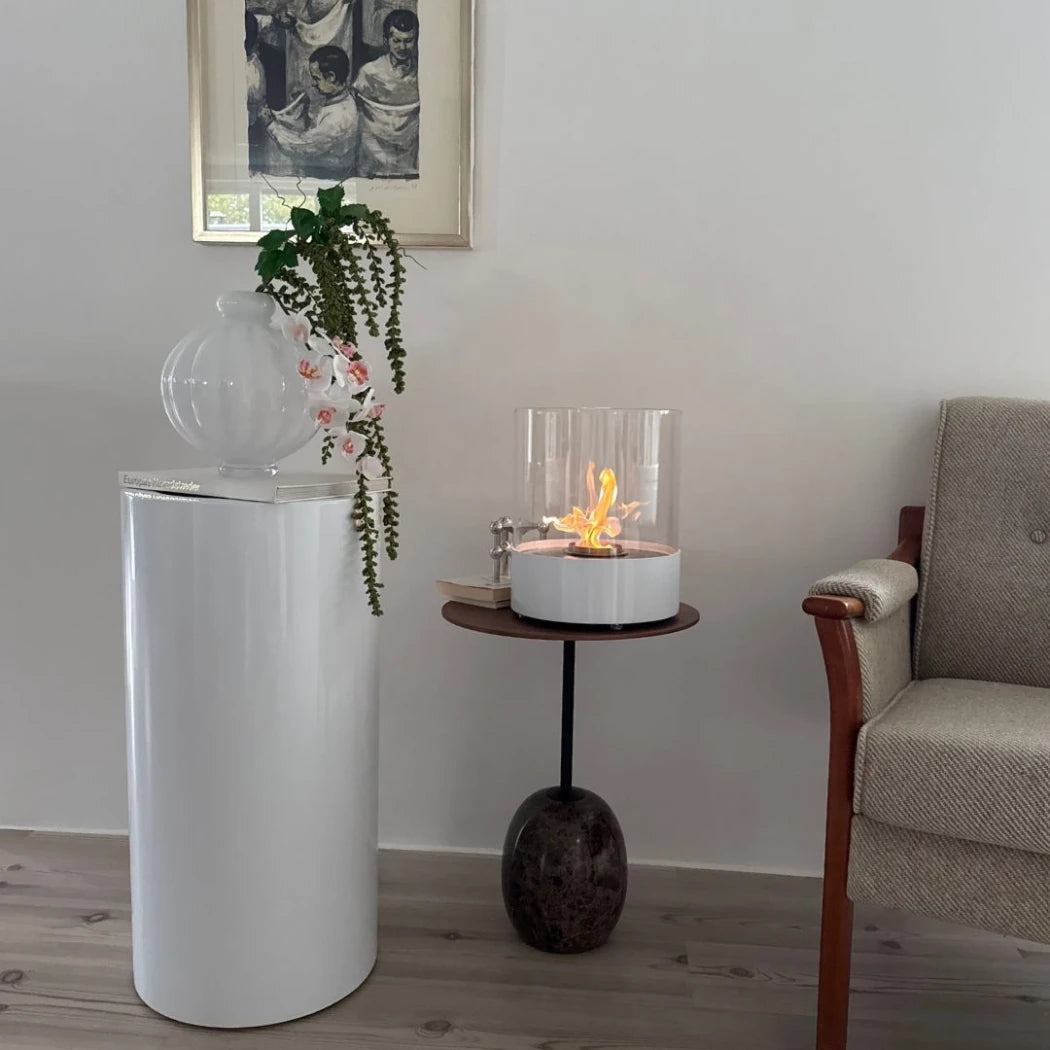 ScandiFlames Dualis bioethanol fireplace with a white fireplace body and a cylindrical safety glass