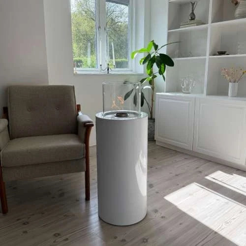 ScandiFlames Dualis bioethanol fireplace with a white fireplace body and a cylindrical safety glass