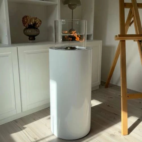ScandiFlames Dualis bioethanol fireplace with a white fireplace body and a cylindrical safety glass